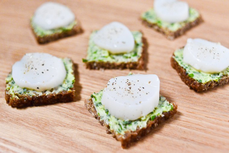 A chic yet easy nibble. Learn how to make herbed butter! Spread it on pumpernickel bread with a sliced scallop on top. Great for a special occasion buffet!