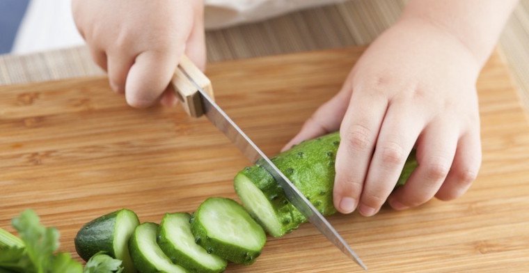 Child slicing a cucumber